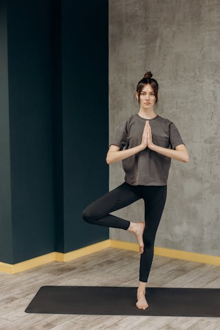 Woman meditating in a lotus position in a warm, dimly lit room.